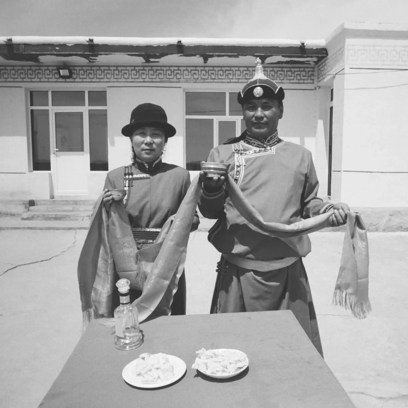 a man and a woman holding ceremonial items