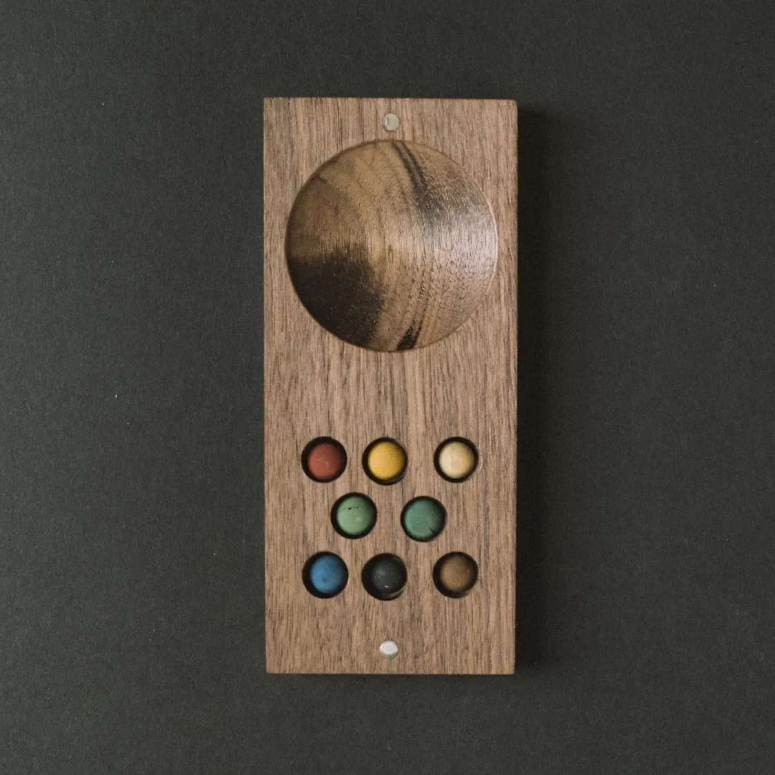 Palette of water color pigments in a routed wooden tray