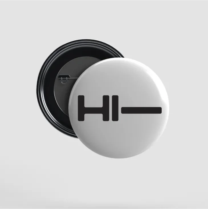 Front and back of button showing "Hi-" on a white background
