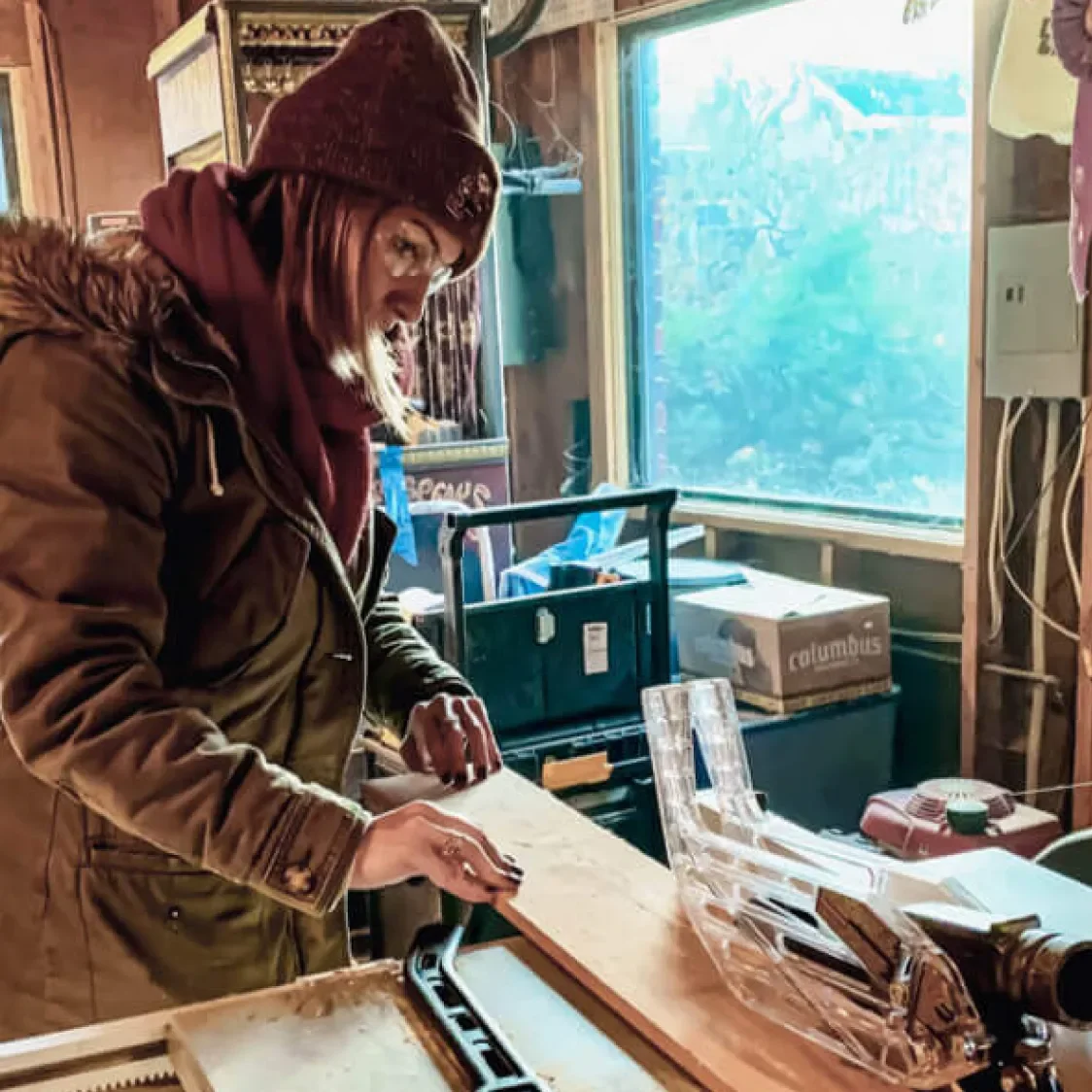 A woman cutting wood on a table saw