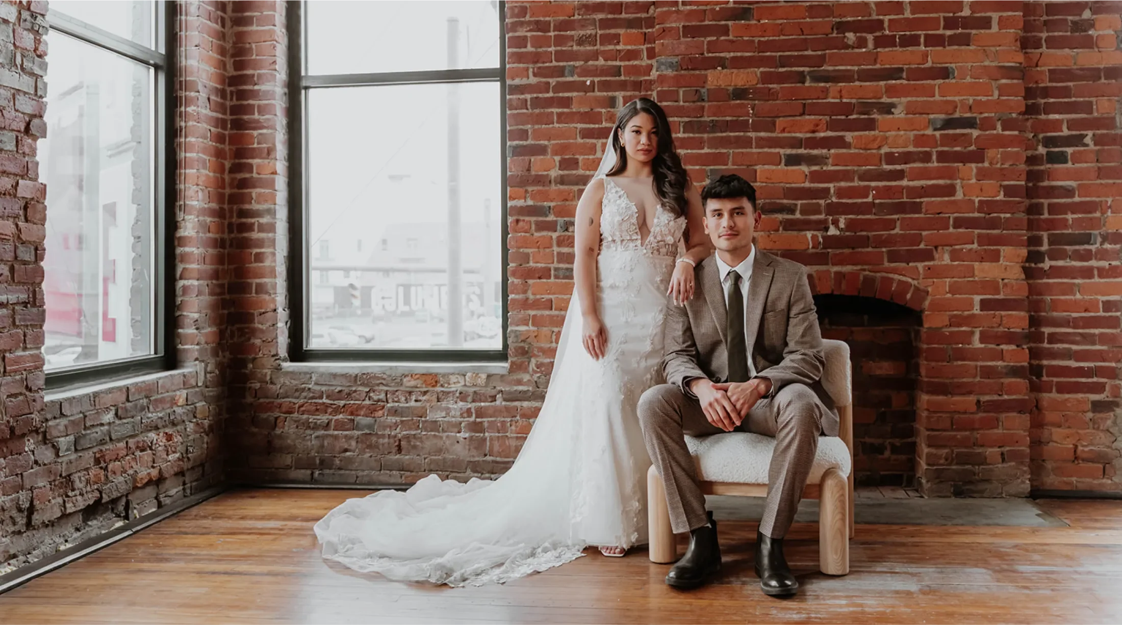 Bride and groom photographed against a brick wall in Hi-Lo