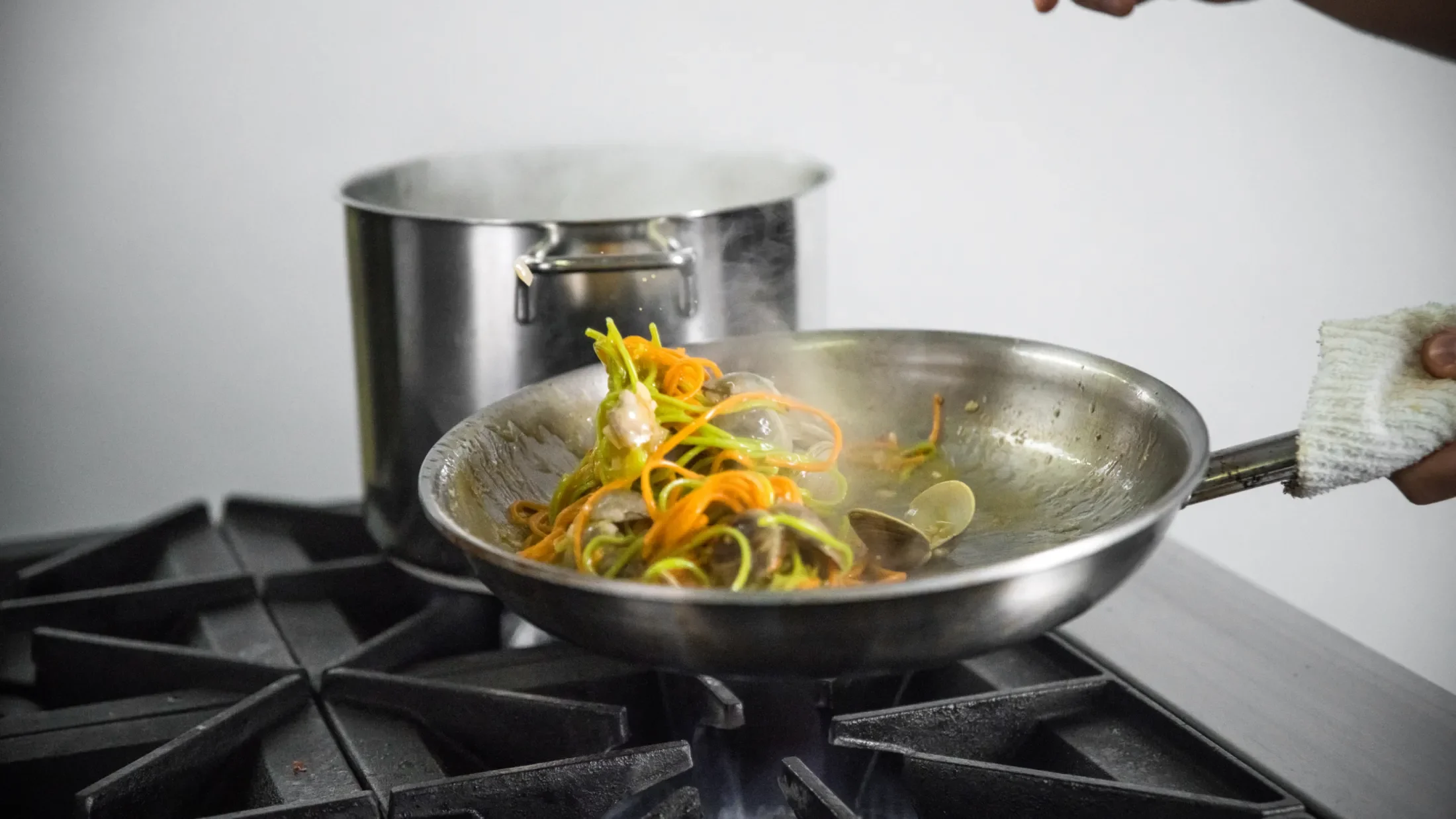 Pan of stir fry being tossed on a stovetop