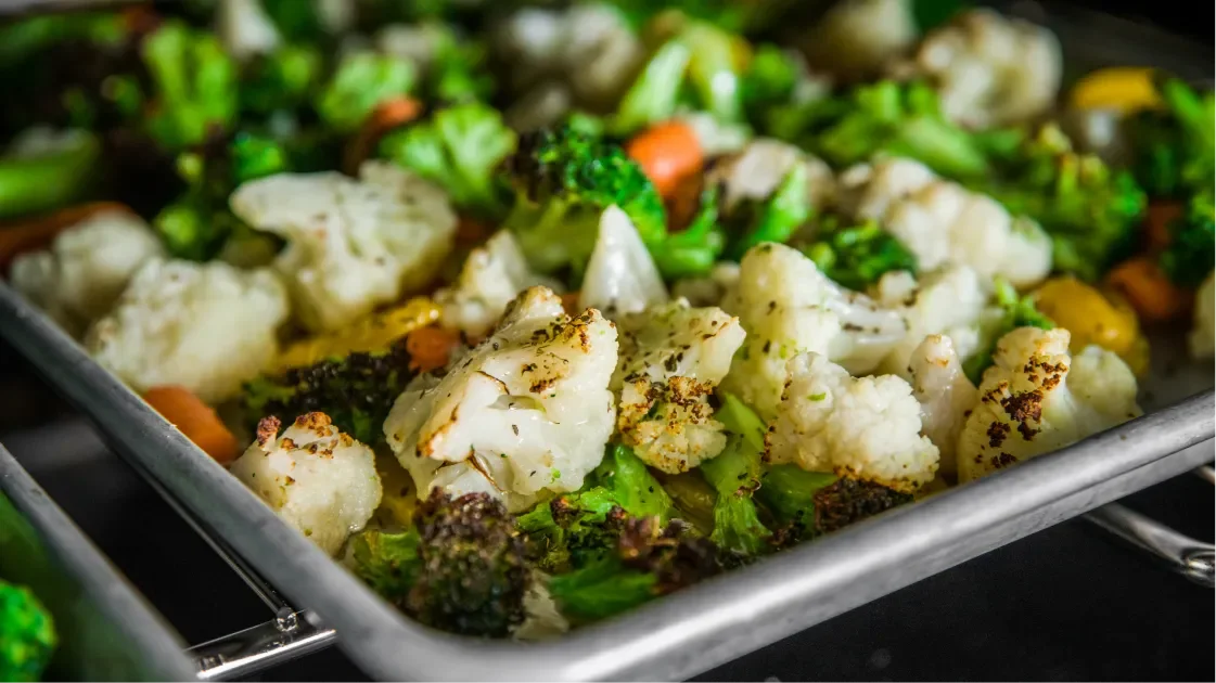 Close-up of a tray of cauliflower, broccoli and carrots in the oven